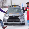 Skiers in Shinshu Sugadaira pose next to a Subaru Slope Taxi