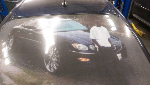 Buick LaCrosse with photo of driver on the back window