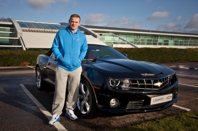 Manchester United player Wayne Rooney, looking positively thrilled with his new Camaro convertible