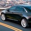 The 2015 Cadillac XTS features swooping lines across the sides and an upright front and rear end.