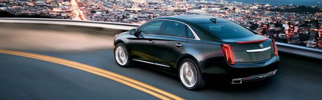 The 2015 Cadillac XTS features swooping lines across the sides and an upright front and rear end.