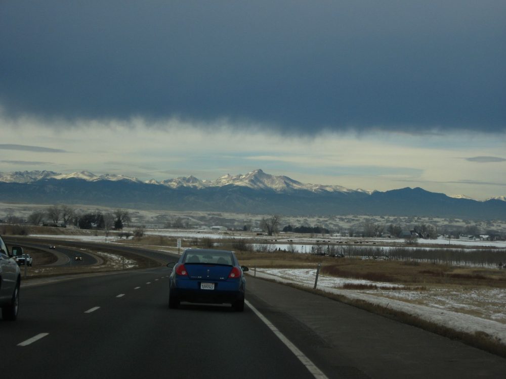 The E-470 toll road in the Denver, Colorado metro area with mountains in the background