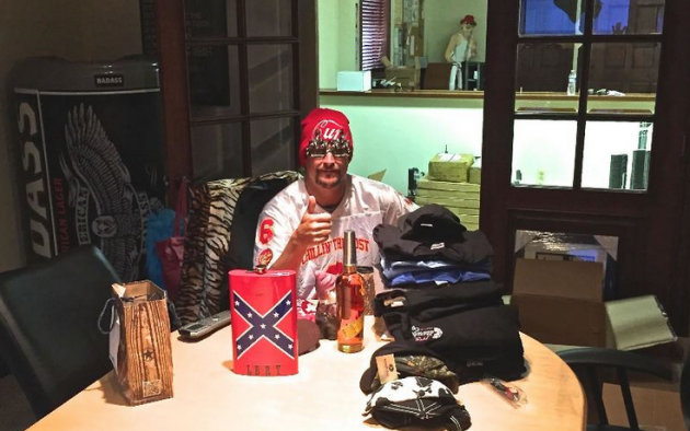 Kid Rock poses with a Confederate flag flask given to him by fans