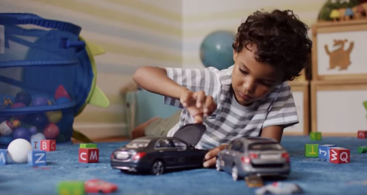 child playing with toy car