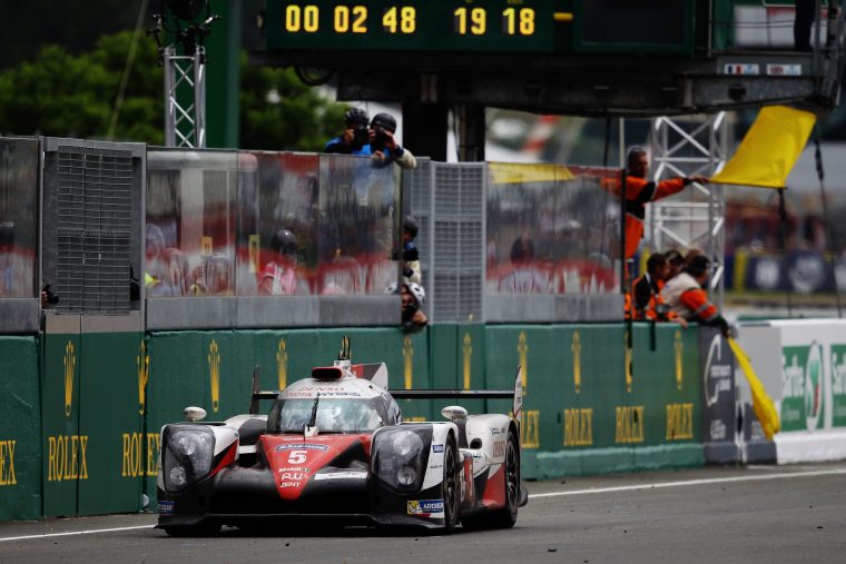 The Toyota #5 TS050 Hybrid at a stop near the pit wall.