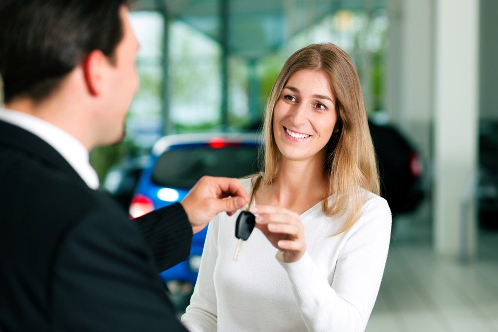 woman car shopping buying leasing at car dealership keys