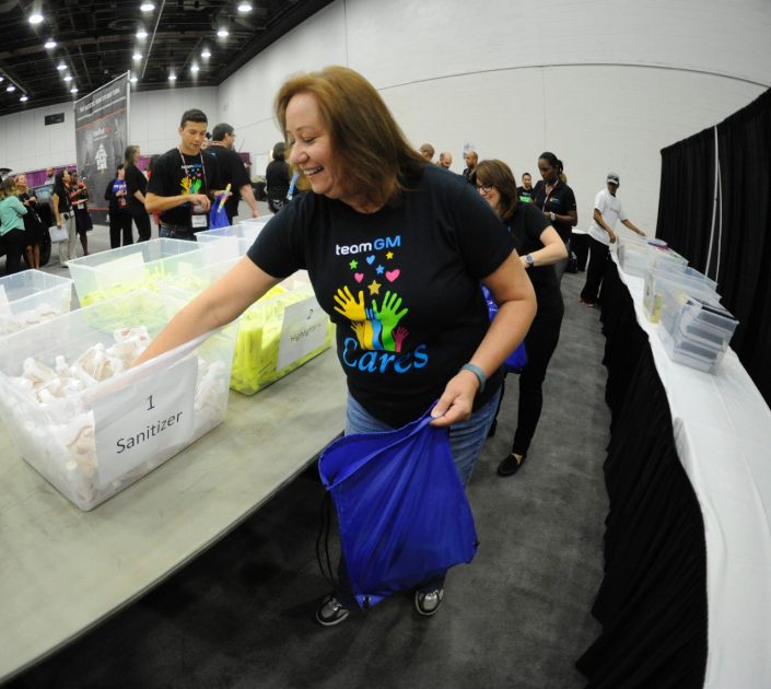 A GM employee fills backpacks with school supplies for kids in Detroit's Cody Rouge community