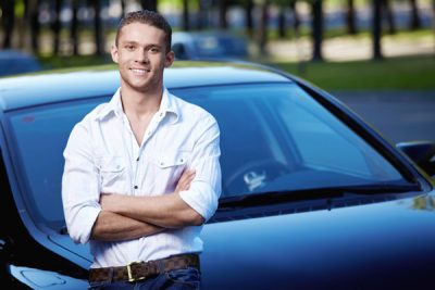 man standing ourside car arms crossed