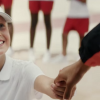 Girl holds medal winner's hand in Toyota ad