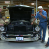 Jay Leno poses with a father and son team of US veterans and the 1957 Chevy 210 that they built together