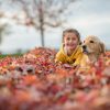 girl with dog in fall autumn leaves