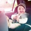 happy baby in car seat with hat