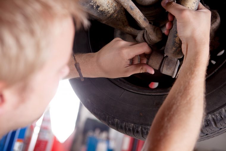 inspecting car tire wheel bearings joints brakes mechanic