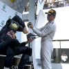 Nico Rosberg helps Daniel Ricciardo prepare a shoey.