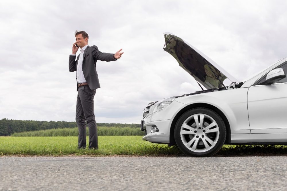 driver on phone making call broken car hood towing