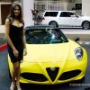 Female model posing with Alfa Romeo car on display at auto show