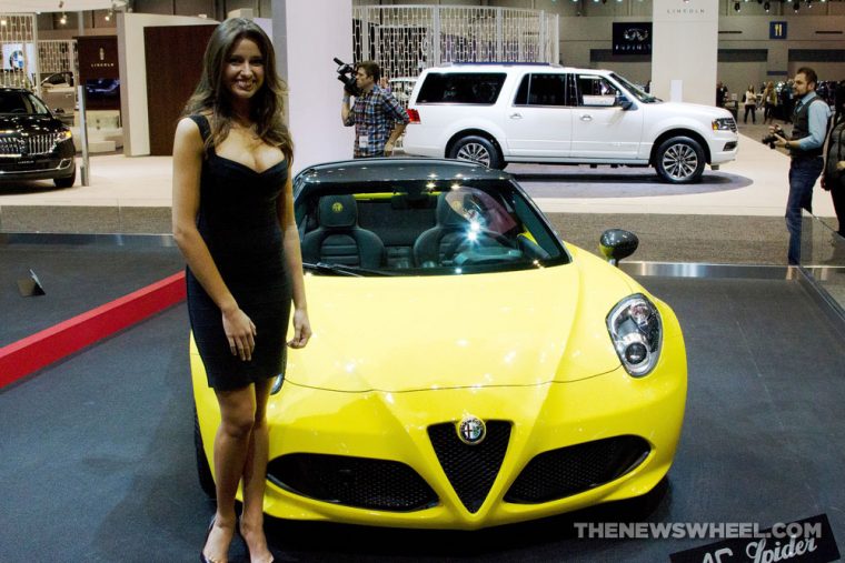 Female model posing with Alfa Romeo car on display at auto show