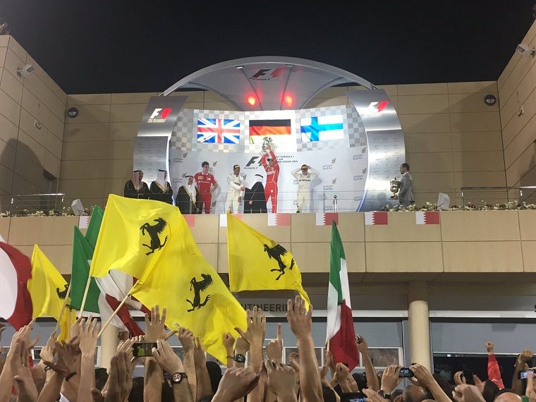 Vettel lifts the 1st place trophy next to Hamilton and Bottas