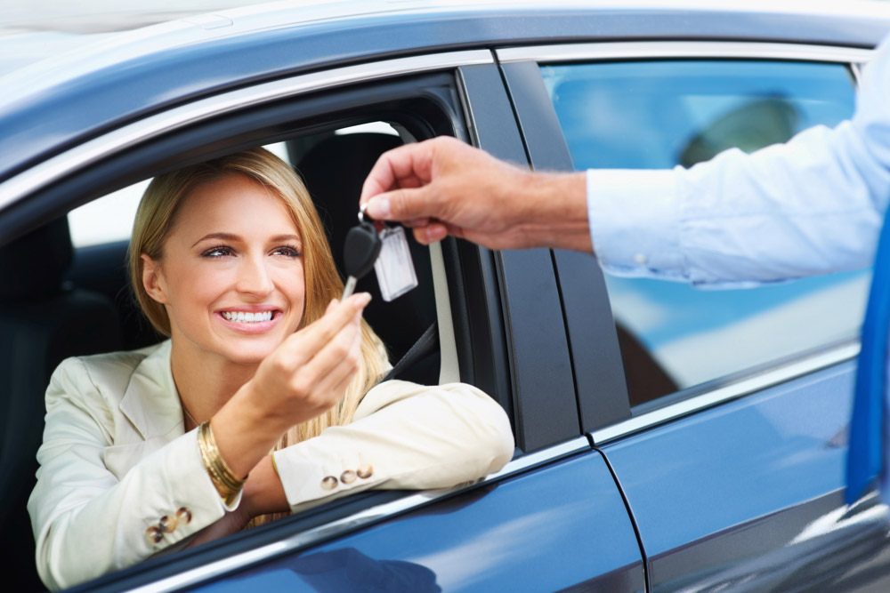 woman taking keys while sitting in car