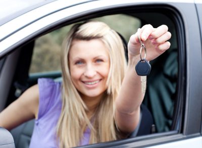 young driver holding out key