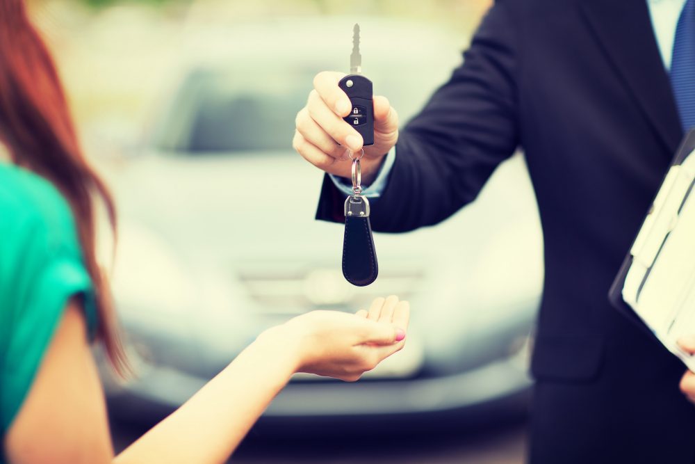 car dealership salesperson car key new car