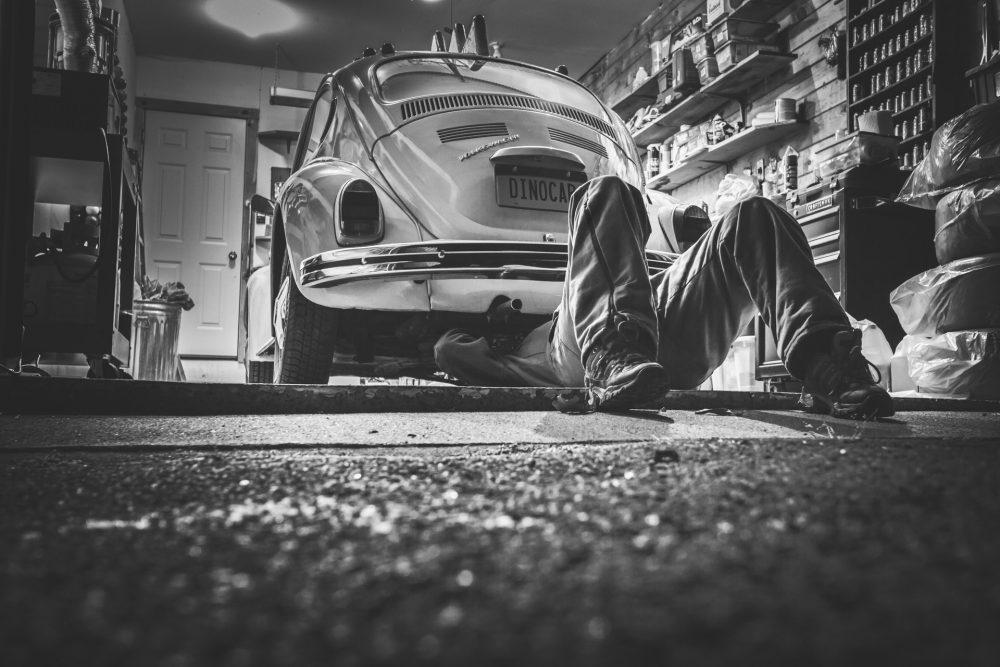 car in garage under the car mechanic