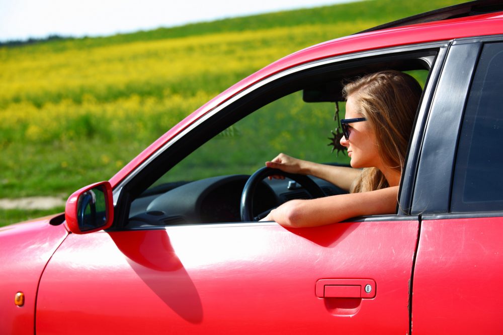 Young woman in red car