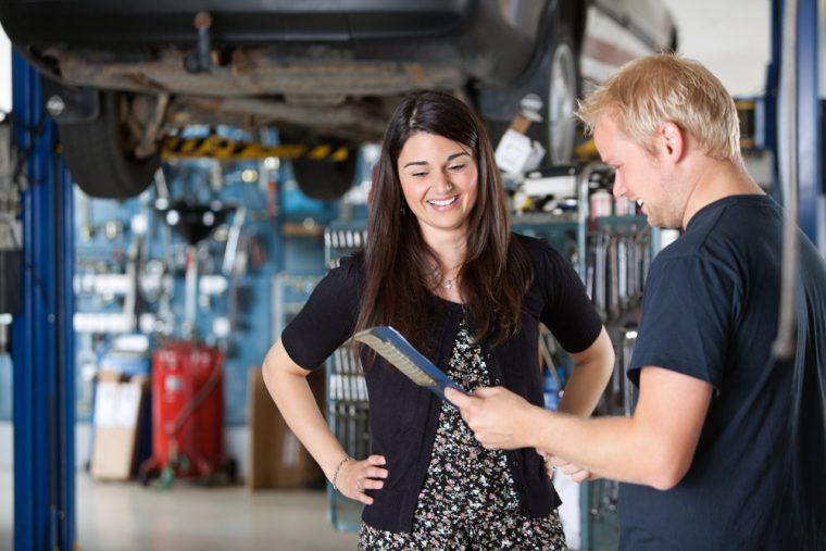 Male mechanic talking to a female customer