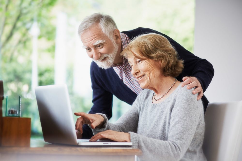 elderly couple shopping browsing online computer laptop at home