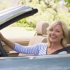 woman driving car convertible healthy happy smiling driver