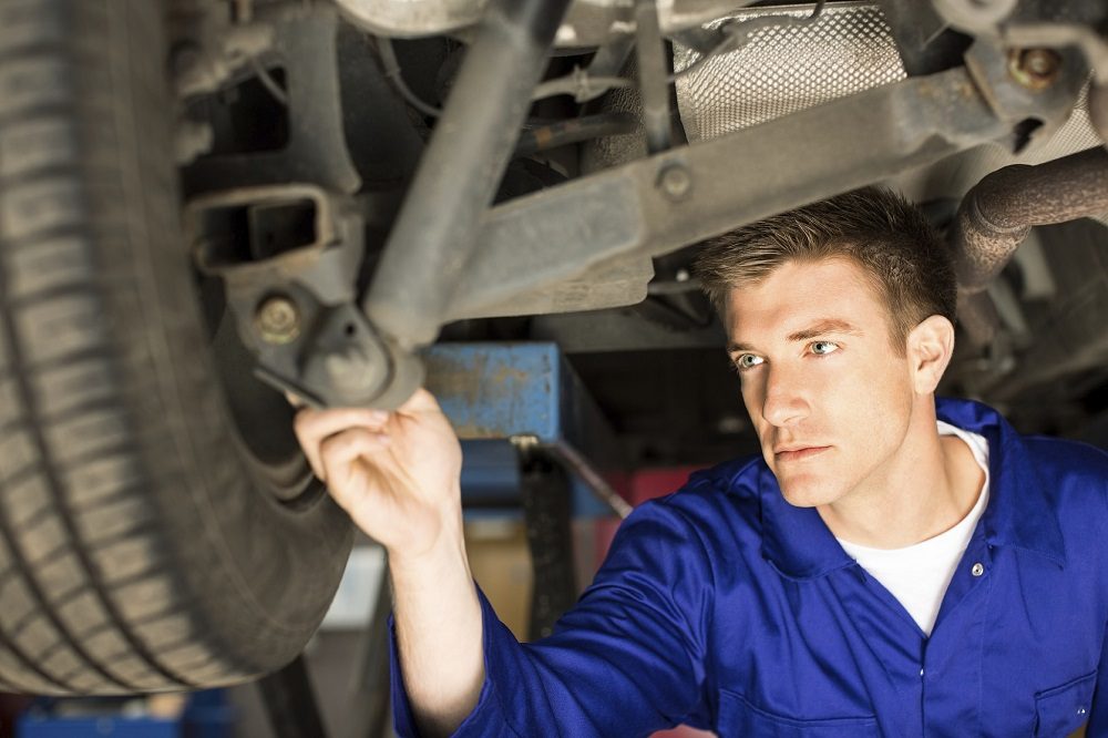 mechanic working on a car in body shop