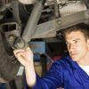 mechanic working on a car in body shop