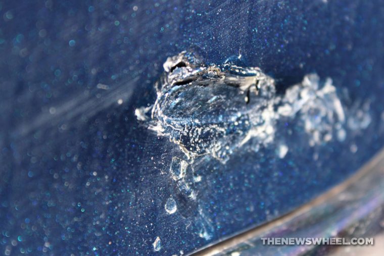 a dent in a car causing paint and body damage 