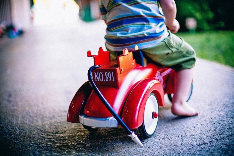 Kid riding on a on toy push Car