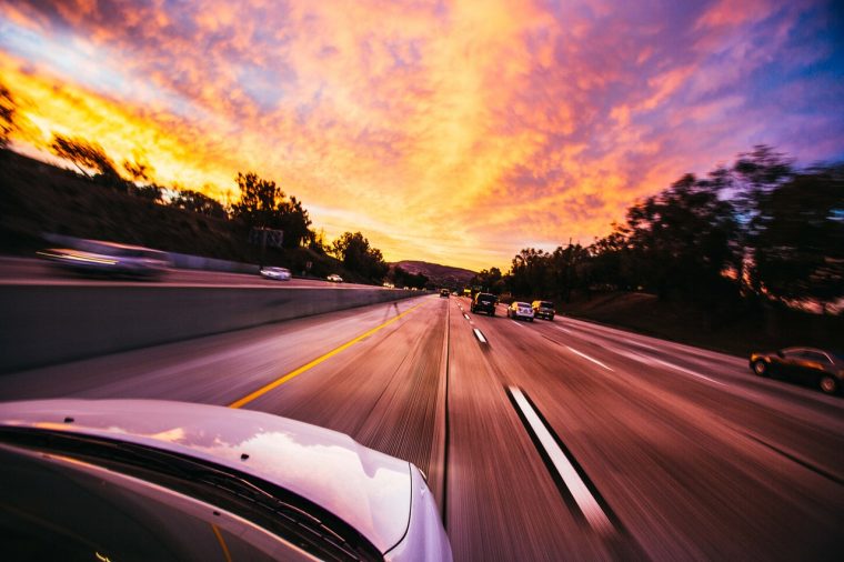 car driving on road at sunset