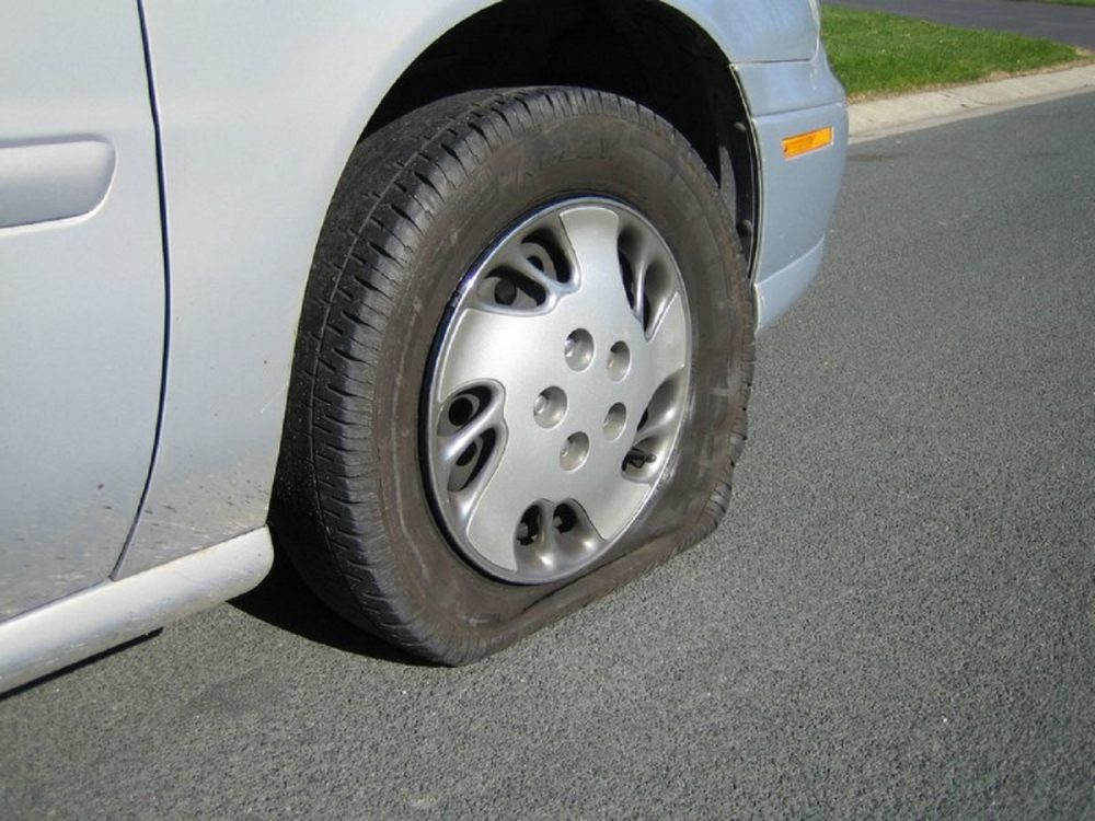 Silver car with flat tire