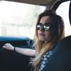 A woman in the passenger seat with sunglasses on