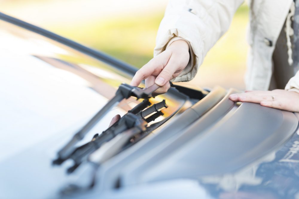 woman's hand picking up windshield wiper