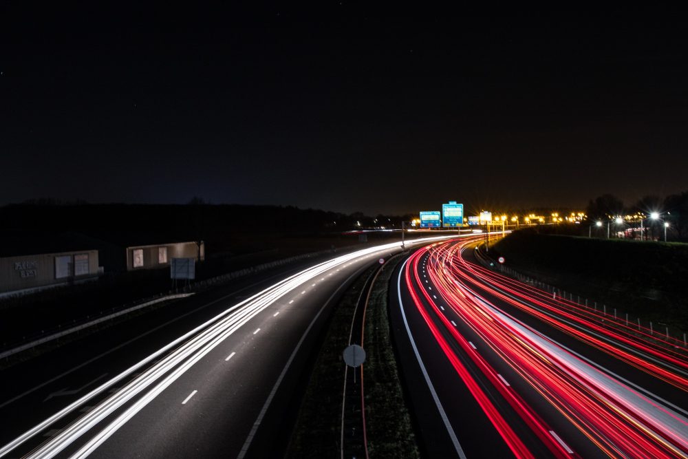 A time lapse photo of a highway taken at night