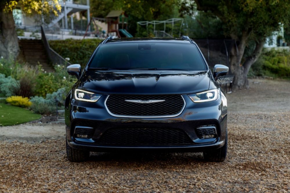 A front view of the 2021 Chrysler Pacifica Pinnacle by a house