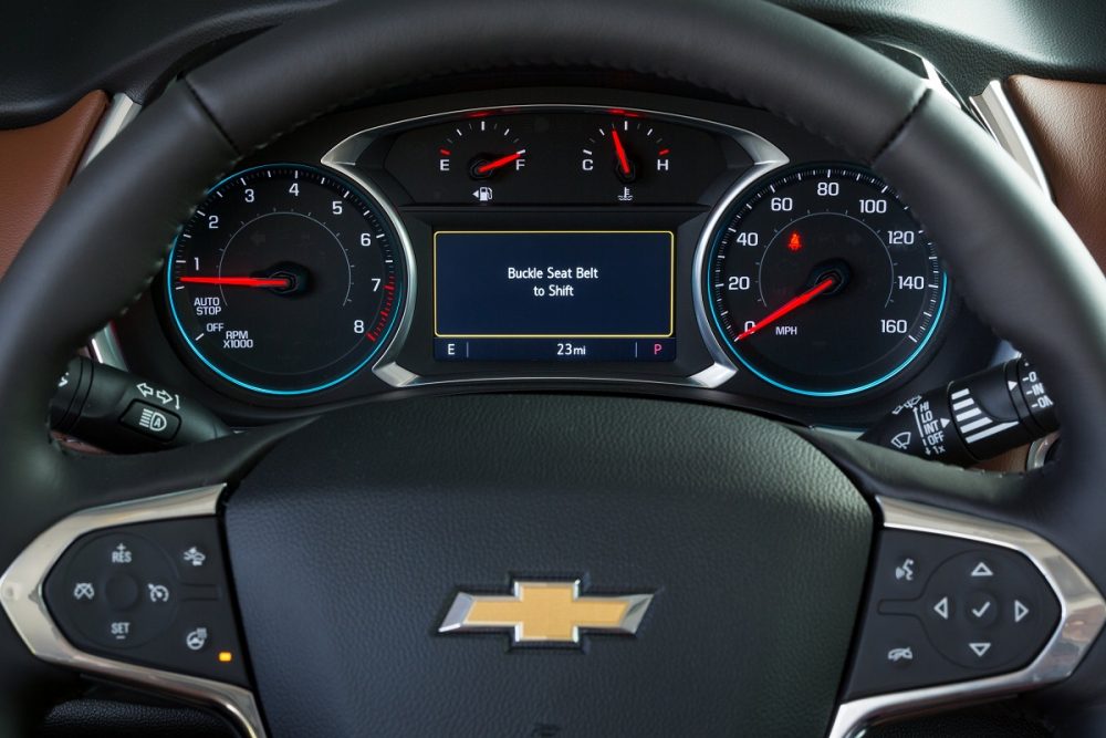 The Buckle to Drive alert next to the gauges and steering wheel of a Chevy