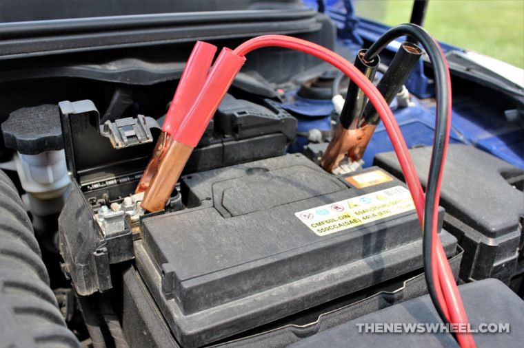 Battery jumper cables connected to a car