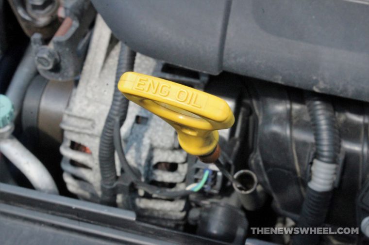 Bright yellow engine oil dipstick handle standing out in the engine bay