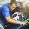 man cleaning interior of vehicle seats