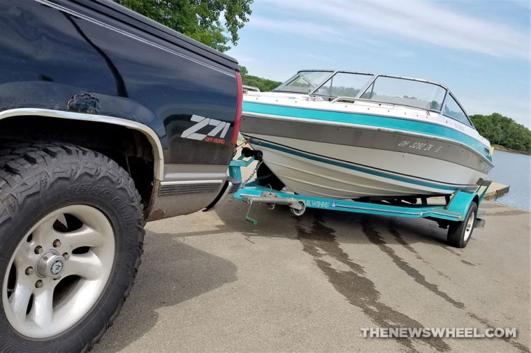 truck towing a boat out of a lake