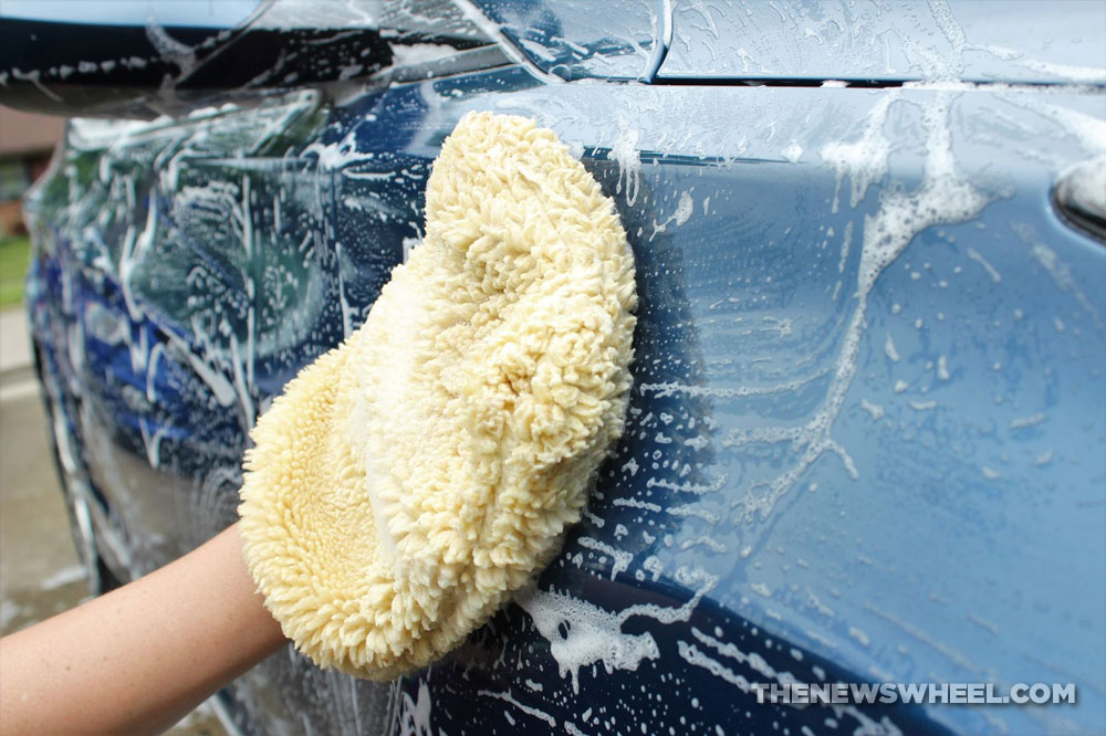 wash car with soap scrubbing mitt and sponge