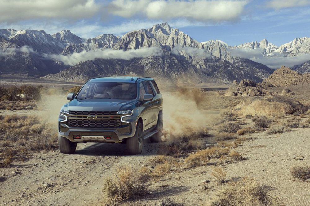 The 2021 Chevrolet Tahoe driving on a dirt road near mountains