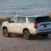 Side and back view of the 2021 GMC Yukon AT4 SUV on a sandy cliff facing the ocean
