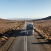 Professional truck driver in Volvo Truck on desert road