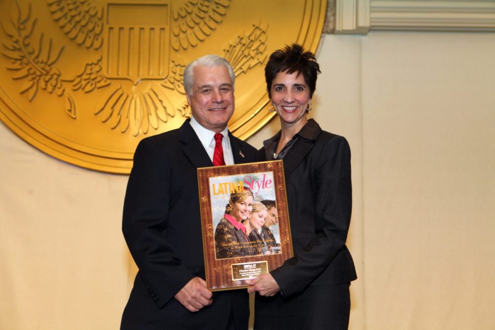 Two FCA employees holding a LATINA Style magazine after making the Top 50 Report